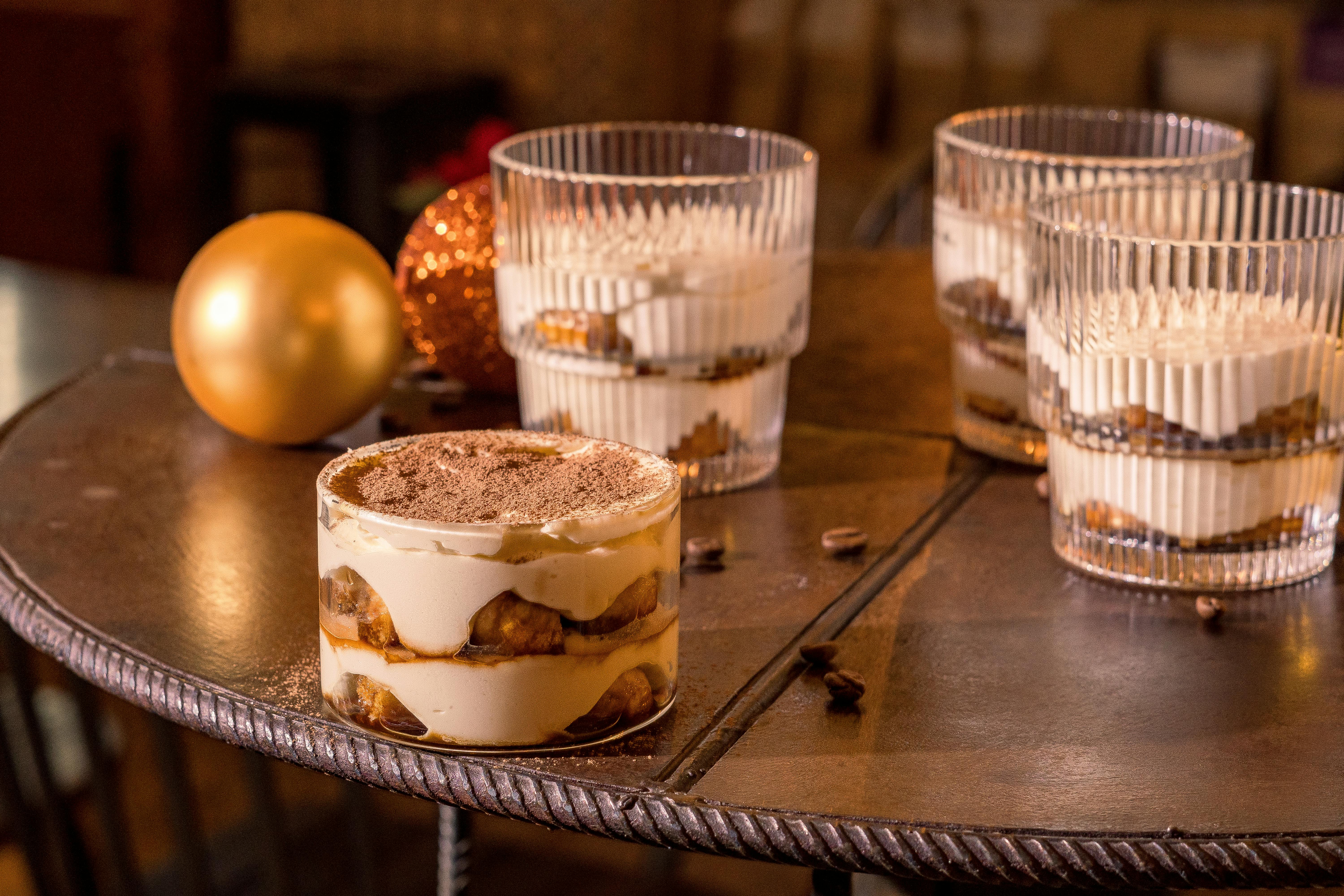Delicious tiramisu dessert served in a cozy cafe setting with festive ornaments.