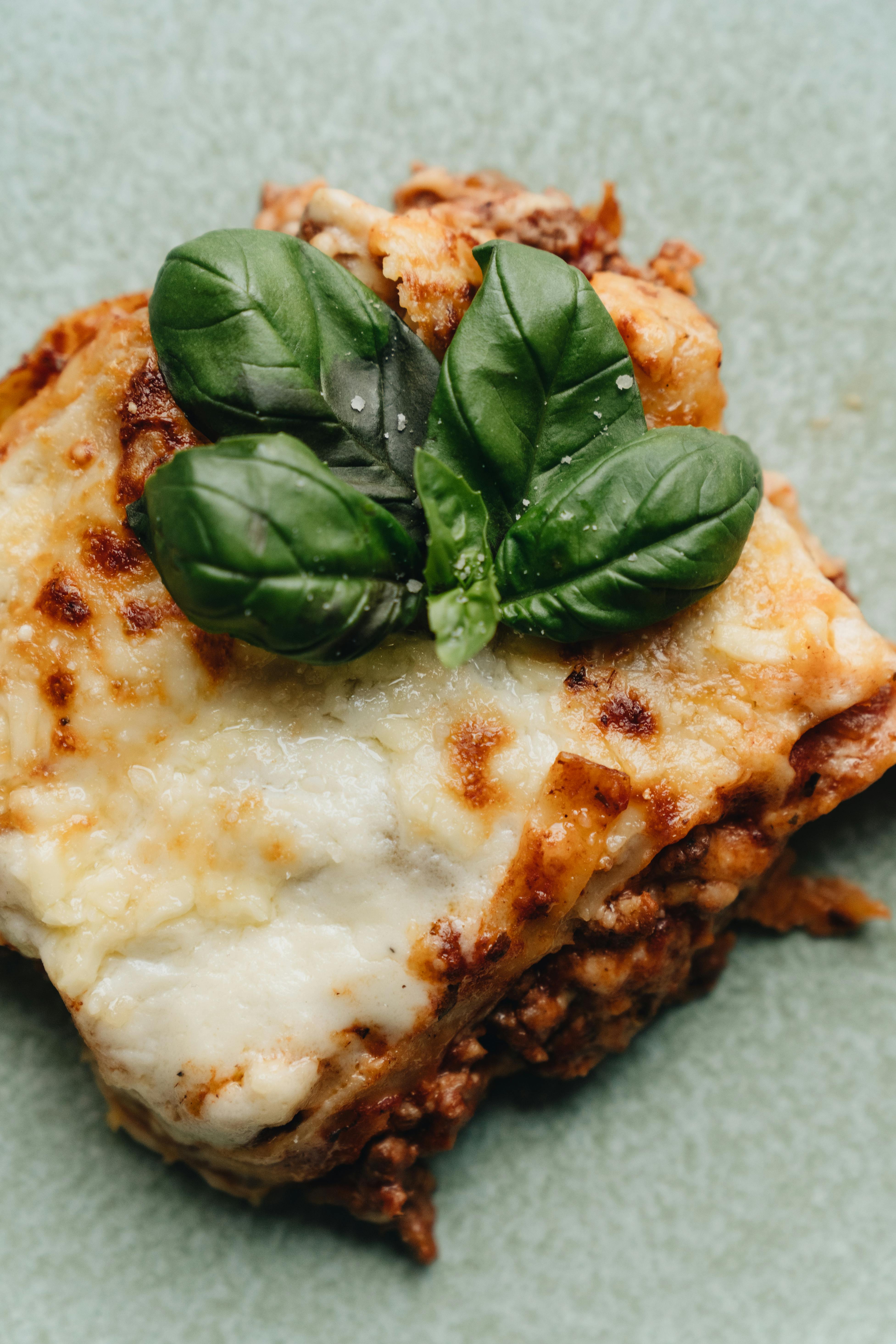 Delicious homemade Italian lasagna topped with fresh basil leaves.
